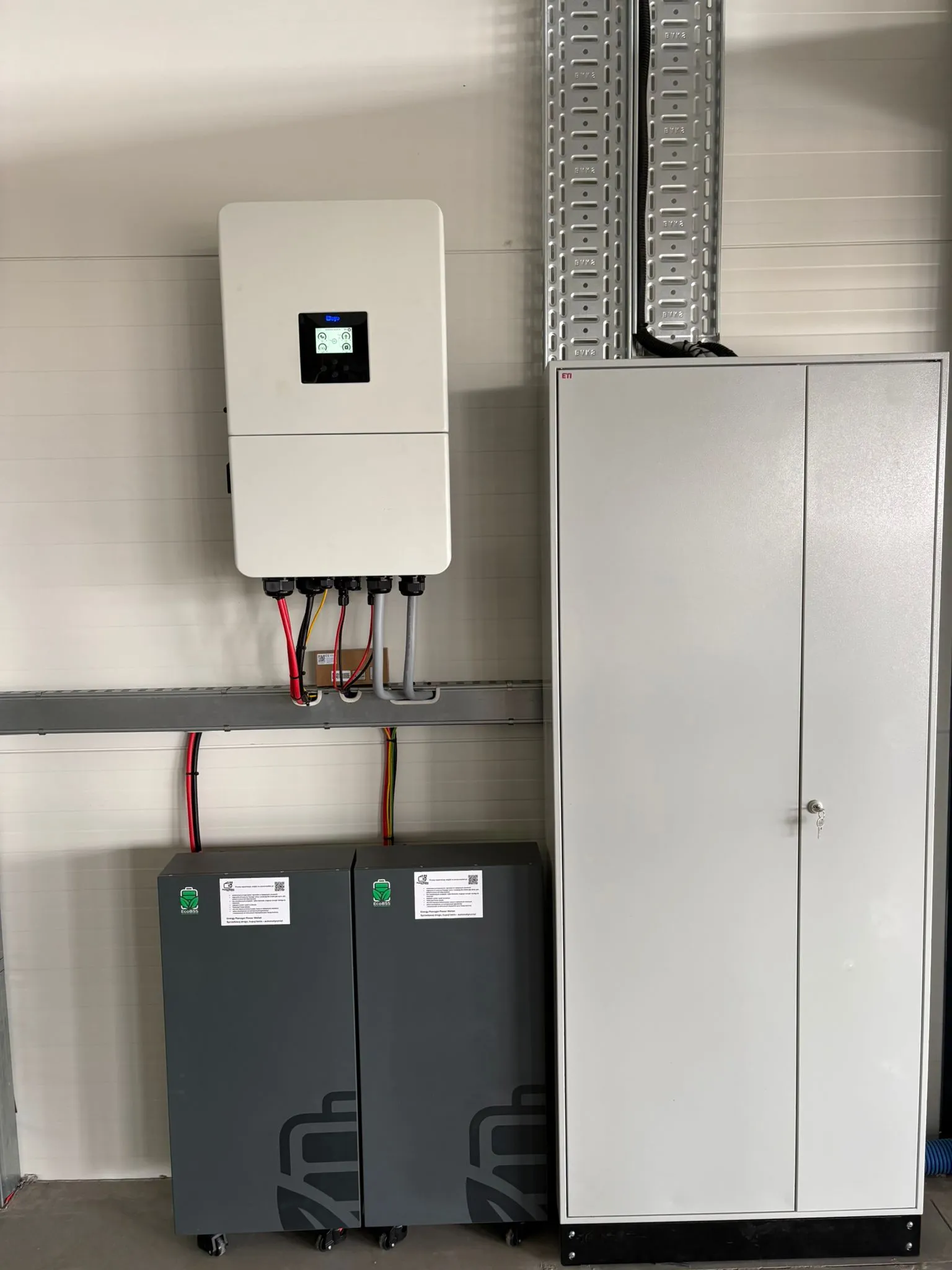 Falownik hybrydowy Deye, dwa moduły magazynu energii i szafa rozdzielcza w pomieszczeniu technicznym